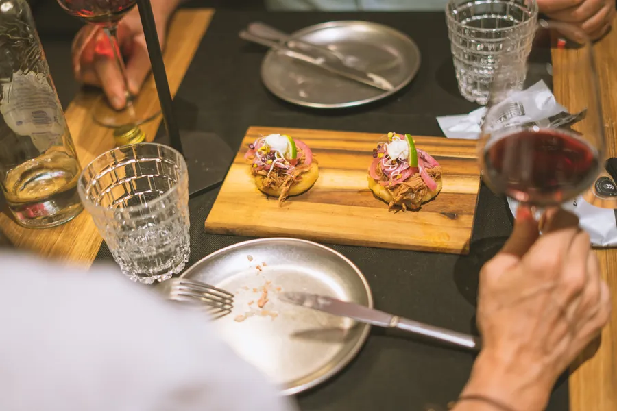 Una tabla de tapas y copas de vino sobre una mesa
