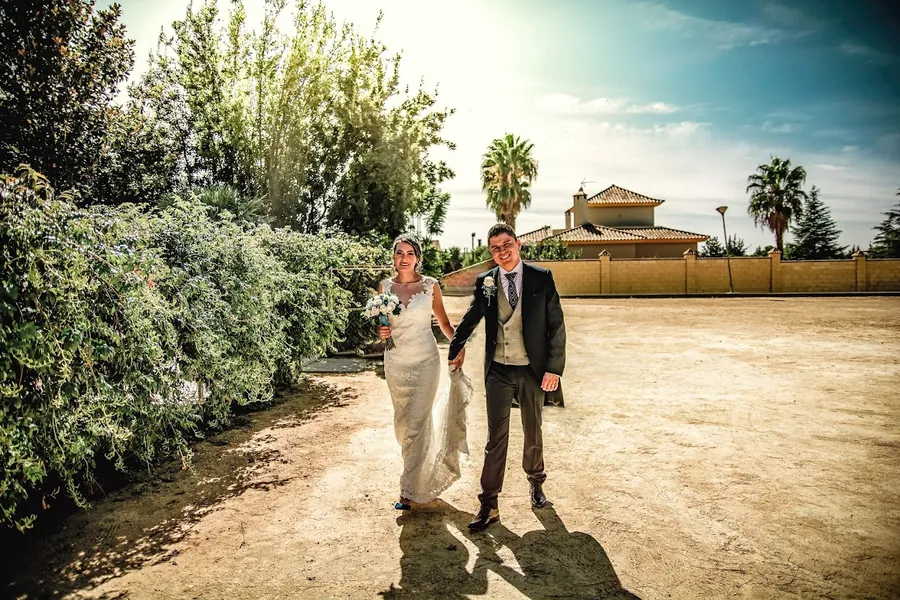 Los novios caminan por un sendero de tierra al sol de la tarde